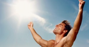 Portrait of an excited young man with hands raised towards the sky